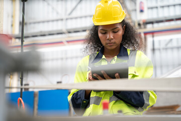 Female engineer using tablet in factory. She looking product or data in tablet at factory.