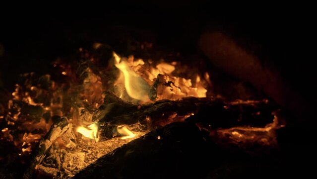 Close up view of campfire flames and fire sparks outside wild nature. Relaxing calm silence bonfire camp orange red flames 
