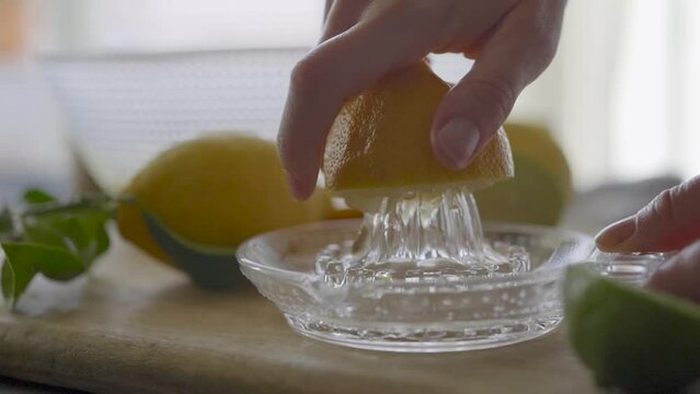 Crop woman squeezing lemon with manual squeezer