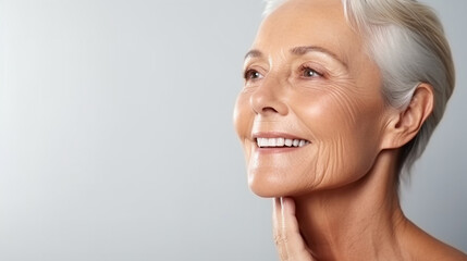 A close-up of a mid-age beautiful elderly senior woman, face skin care beauty - obrazy, fototapety, plakaty