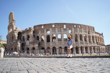 Travel woman sitting and looking on Coliseum, Rome, Italy. Beautiful tourist girl near Colosseum....