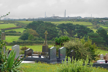 Cemetry in rural La Hague, with the horizon filled by Orano La Hague. the worlds largests nuclear...