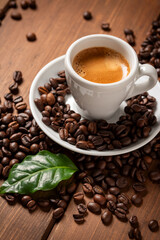 Fototapeta premium Tazzina di caffè espresso con chicchi e foglia, colazione italiana 