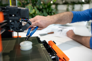 Engineers working with 3D printer process of printing.