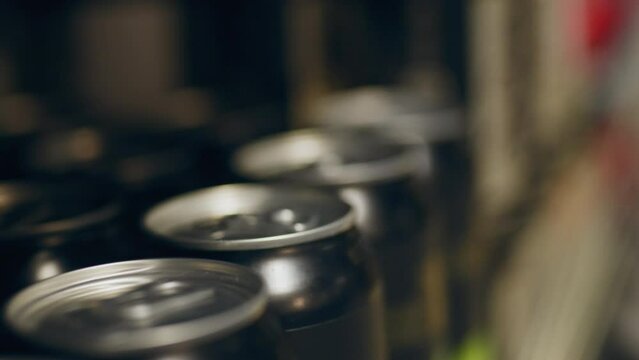 Close-up of tin cans on a store shelf. Beer in metal can on the display of a beer bar in a grocery store in the alcohol department. Metal beer cans review: selection and purchase of beer in the store