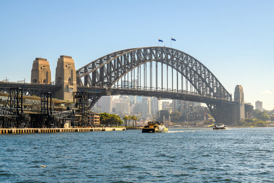 Sydney Harbour Bridge with ferries and Sydney North buildings in the background on a day