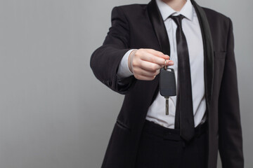 Obraz na płótnie Canvas Car key. Businessman holding the car key on gray background