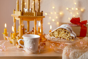 Christmas wooden carousel with candles, German Christmas bread-shaped cake stollen, mug of hot coffee, tea, Holiday Atmosphere, Winter Holiday Vibes