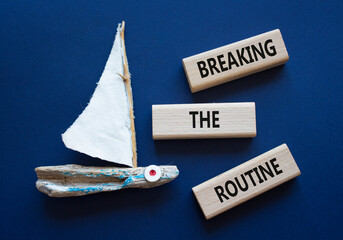 Breaking the Routine week symbol. Concept words Breaking the Routine on wooden blocks. Beautiful deep blue background with boat. Business and Breaking the Routine concept. Copy space