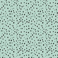 Seamless abstract vector pattern. Chaotic black dots on a green background.