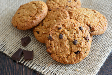 healthy oatmeal biscuits with chocolate chips lying on the burlap tablecloth  