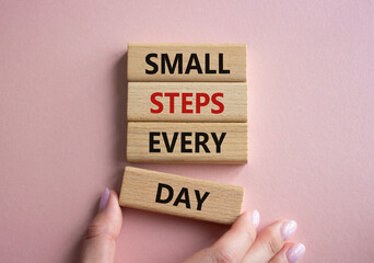 Small Steps Every Day symbol. Wooden blocks with words Small Steps Every Day. Beautiful pink background. Businessman hand. Business and Small Steps Every Day concept. Copy space.