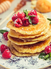 Appetizing pancakes with raspberries and honey