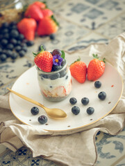 Appetizing yogurt with fresh berries on table