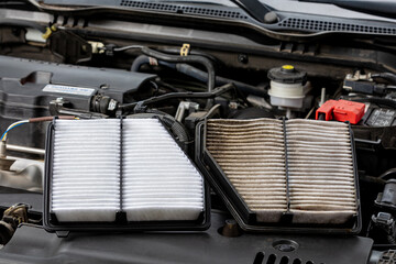 New and old, dirty air filter side by side on vehicle engine. Automotive repair, maintenance, service and fuel mileage concept - obrazy, fototapety, plakaty