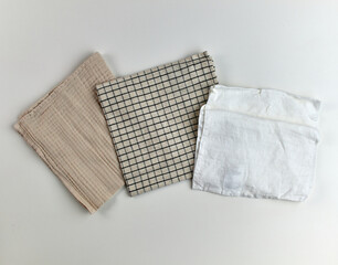 Napkins and towels on white background. Kitchen textiles, top view