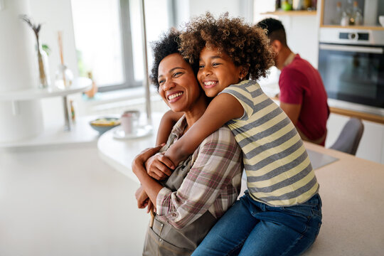 Portrait of african mother hugging with her daughter, enjoying moment of love, having fun together