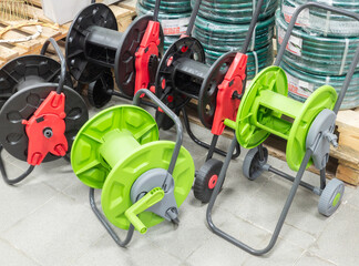 Garden reels and rolled hoses in a store, supermarket, mall store. Garden hose reel for watering plants.