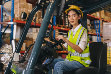 Forklift driver young staff lady worker in warehouse logistics loading cargo products storage...