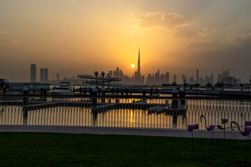 Dubai during a beautiful Sunset with the sun next to Burj Khalifa. High-quality photo