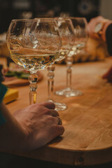 Three wine glasses with a woman holding onto one