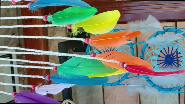 Multicolored feathers of Dreamcatcher are swaying in wind.