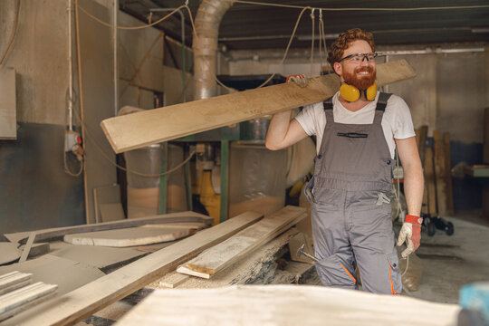 Male woodworker working on carpentry manufacturing with wooden board. High quality photo