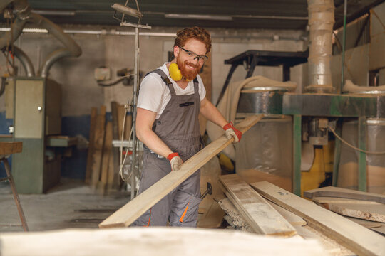 Professional male carpenter working on carpentry manufacturing with wooden board
