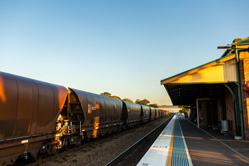Coal train passing Singleton station at sunrise