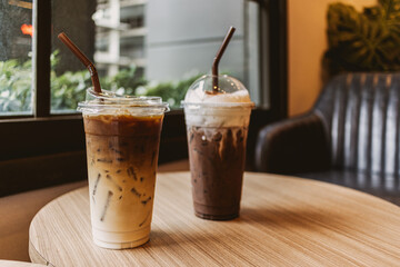 Glasses of iced Coffee and iced cocoa, two drinks beverages are on the table at cafe.