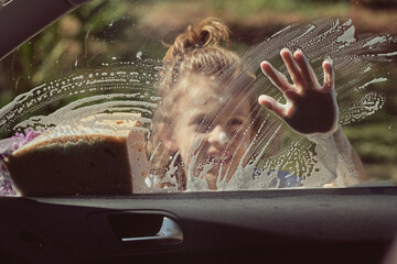 Boy washing window of car