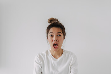 Asian Thai woman bun hair, funny wow face, surprised amazing, isolated on white background in winter.
