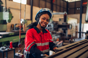 Portrait of female automation engineer standing in modern industrial factory and looking camera in industrial factory.