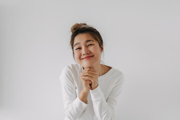 Asian Thai woman funny cute, keeps palm together, has pleased expression, begging asks boyfriend to...