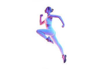 Side view portrait of young sporty woman running in action isolated against white background in neon light.