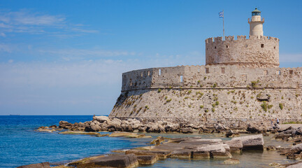 Mandraki port and fort of St. Nicholas. Rhodes, Greece. Hirschkuh statue in the place of the...