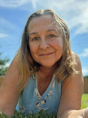 senior adult woman portrait laying in grass