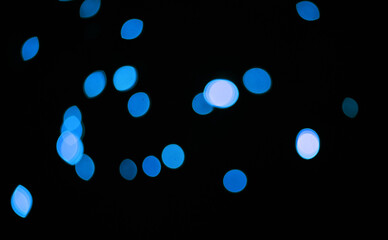 Blue, glitter and bokeh in a studio with dark background for celebration, event or party. Confetti, lights and color sparkles for magic, shine or glow for festive by black backdrop with mockup.