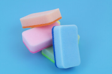 Five colorful sponges om blue background. 