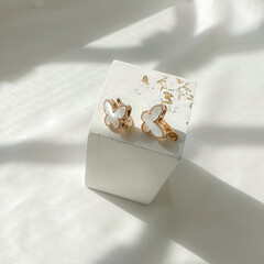 Sweet Alhambra butterfly earrings on plaster figure, 14K pink gold, white mother-of-pearl. Fine jewelry for women, gift for her.