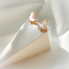 Sweet Alhambra butterfly earrings on plaster figure, 14K pink gold, white mother-of-pearl. Fine jewelry for women, gift for her.