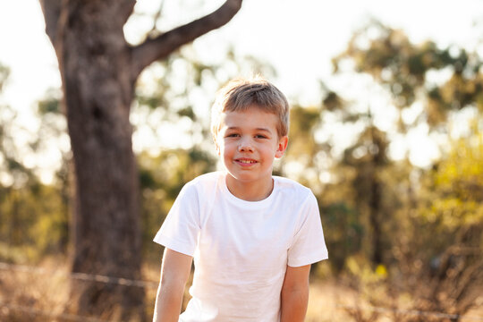 Smiling portrait of Australian boy in country setting with bokeh backdrop