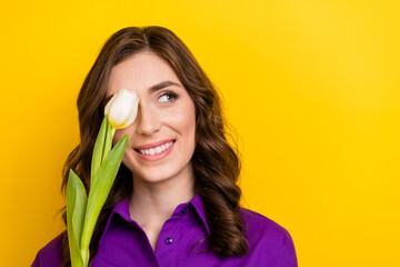 Photo of nice creative minded girl tulip flower cover one eye look empty space isolated on yellow...