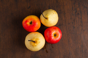 red pears and apples on a wooden base, in the photo from above