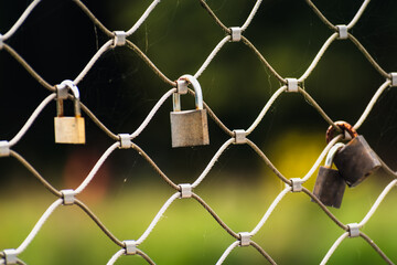 Naklejka premium Rusty padlocks attached to the metal railing of a bridge, tradition of padlocks, symbol of eternal love