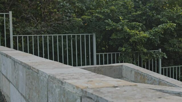 Back view of acrobatic parkourist girl doing front handspring while practicing parkour tricks outdoors