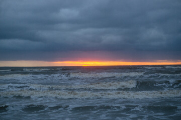 Naklejka na ściany i meble Stormy sea at sunset. Winter.