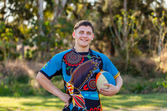 Smiling portrait of happy young aboriginal sports player with ball