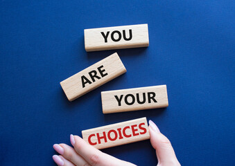 You are Your Choices symbol. Concept words You are Your Choices on wooden blocks. Beautiful deep blue background. Businessman hand. Business and You are Your Choices concept. Copy space.