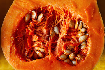 Cut pumpkin. Pumpkin texture. Pumpkin seeds close up. Orange vegetable. Diet food concept. Vegetarian food. Selective focus
